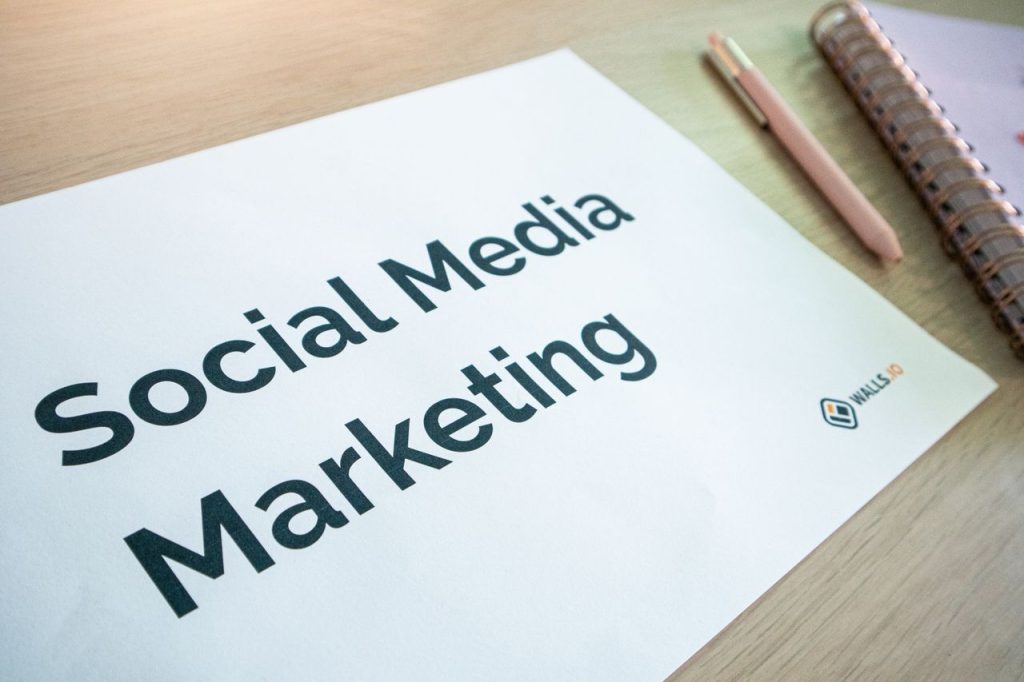 Top 10 Social Media Tricks to Go Viral in 2026 Close-up of a social media marketing document on a desk with a pen and notebook.