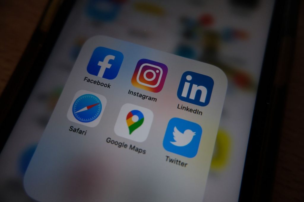 Top 10 Social Media Tricks to Go Viral in 2026 Close-up view of popular social media app icons on a smartphone screen.